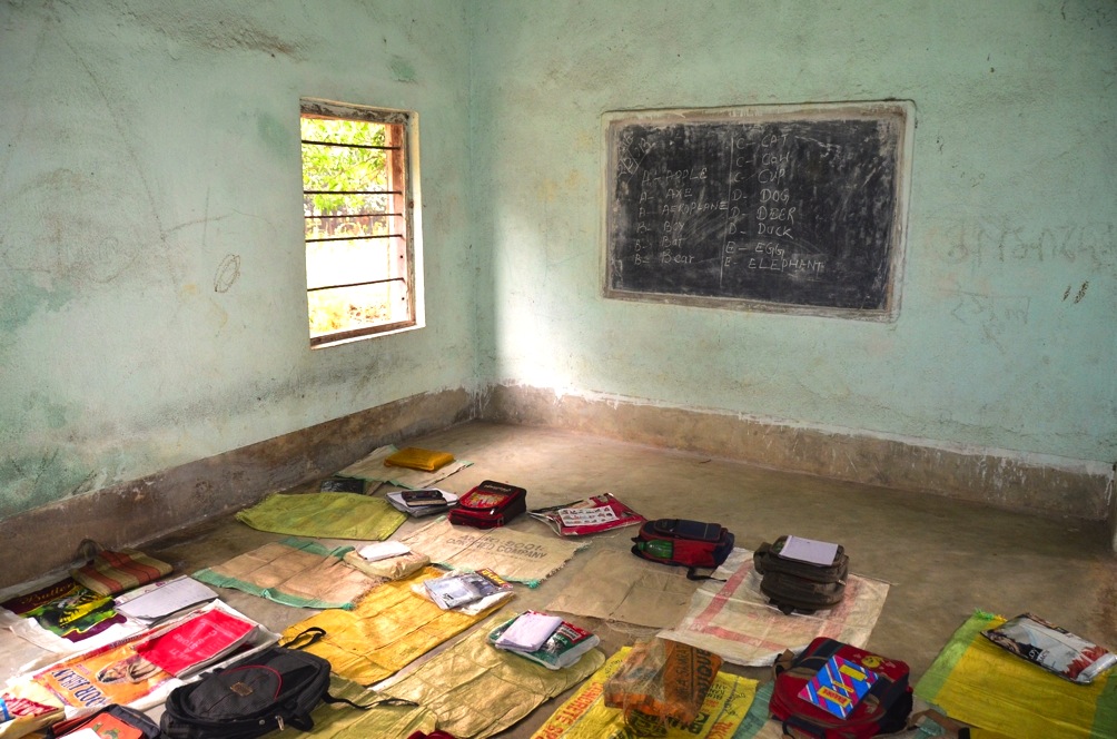 A simple village school classroom with learning materials arranged on floor mats