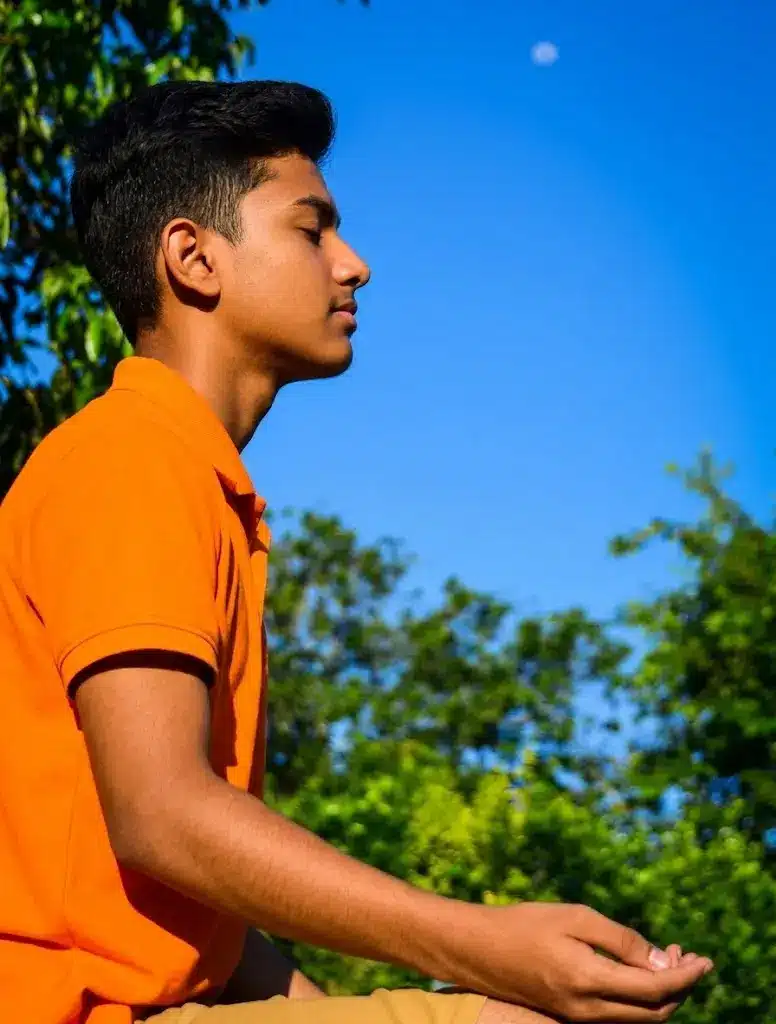 A young person practising meditation at Ánanda Nagar