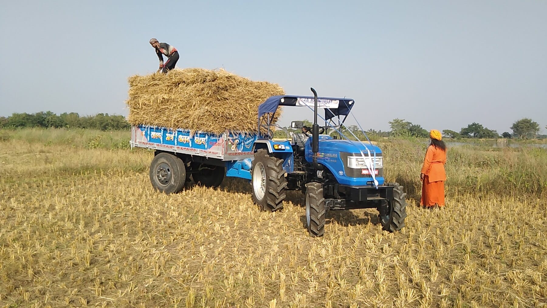 A tractor and trailer carrying the harvested crop at Ánanda Nagar